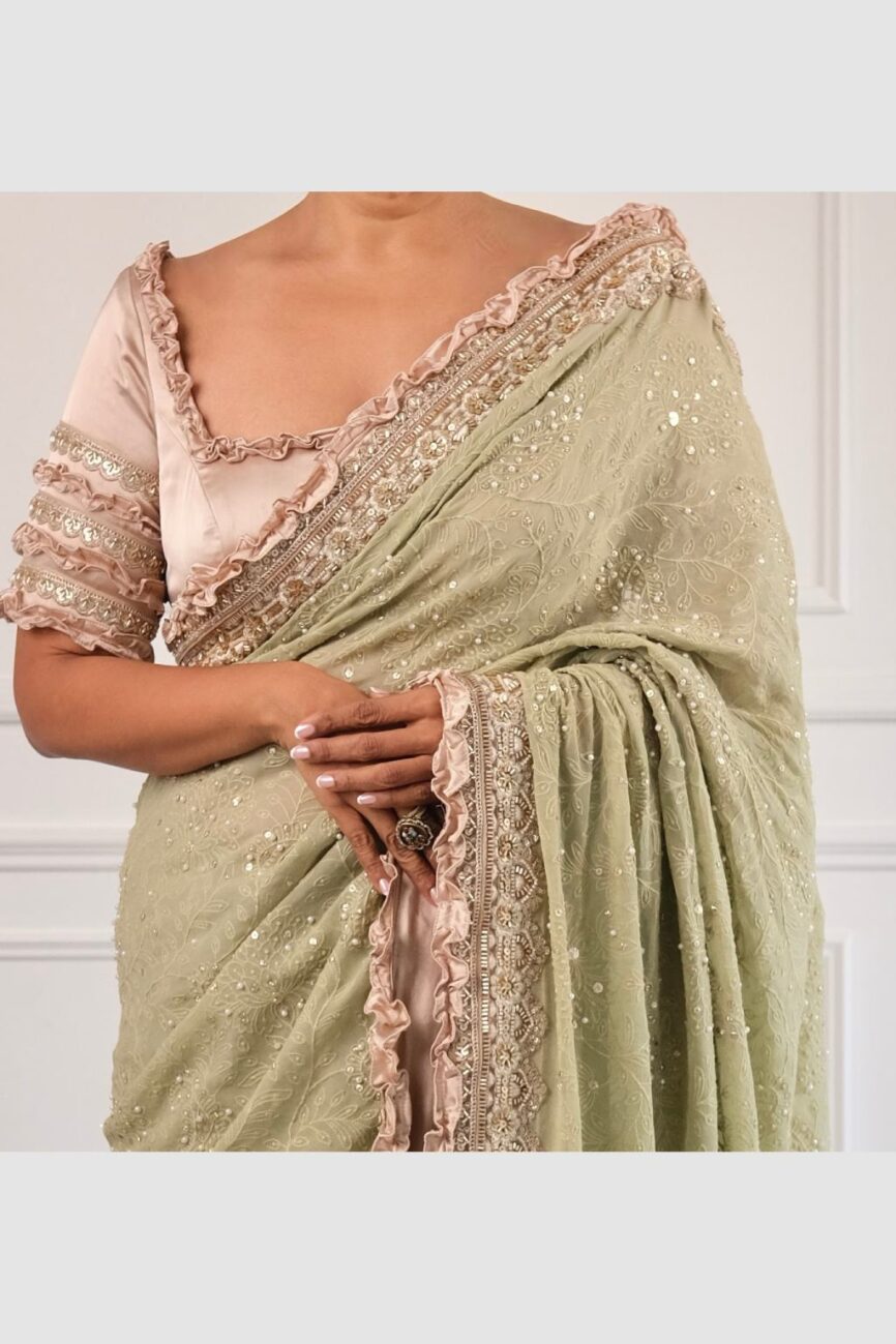 Close-up of chikankari embroidery on green and taupe saree.