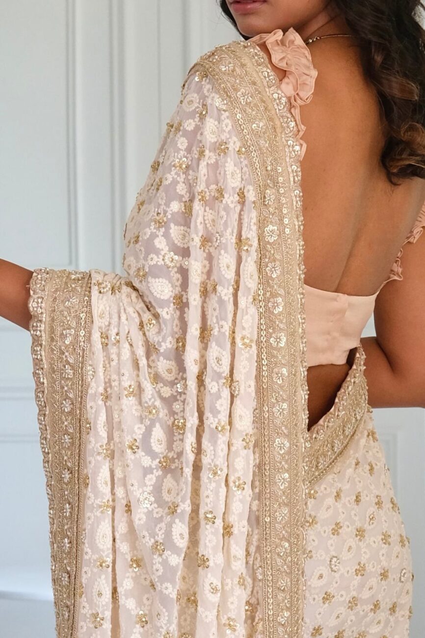 Close-up of chikankari hand embroidery on ivory saree.