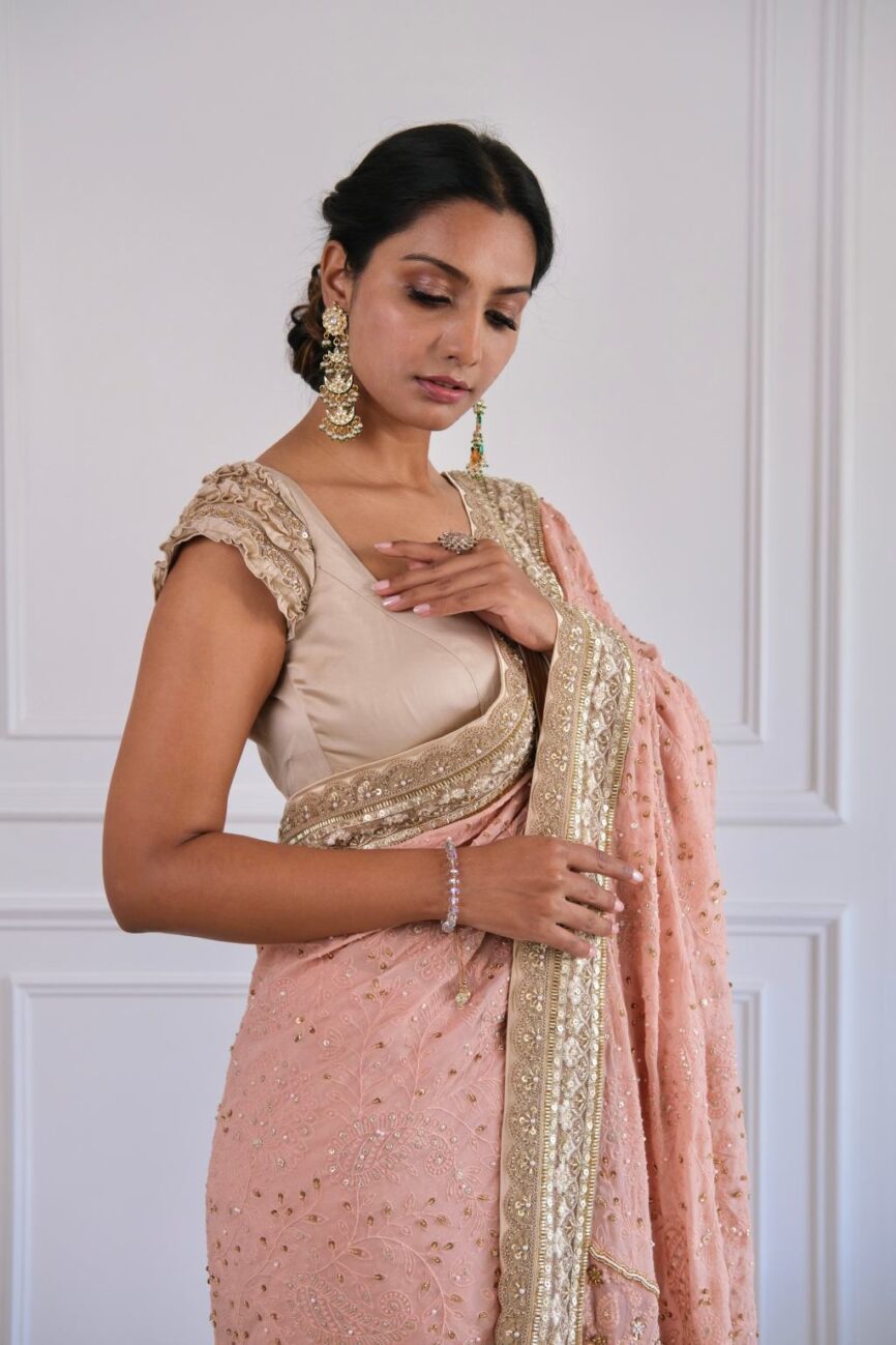 Close-up of hand-embroidered chikankari work on pink and taupe saree.